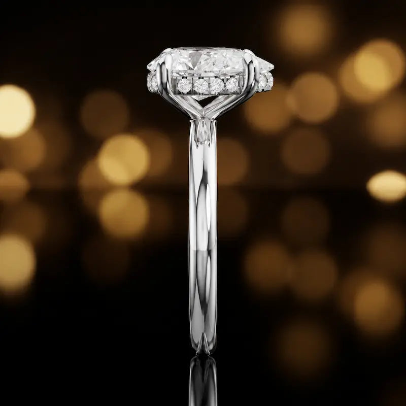 Side profile of 4-claw pear cut engagement ring with hidden halo in 18kt white gold