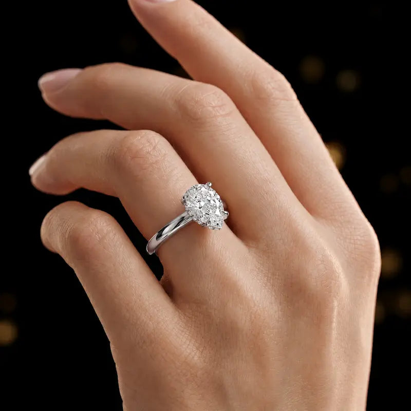 4-claw pear cut engagement ring with hidden halo in 18kt white gold, worn on hand