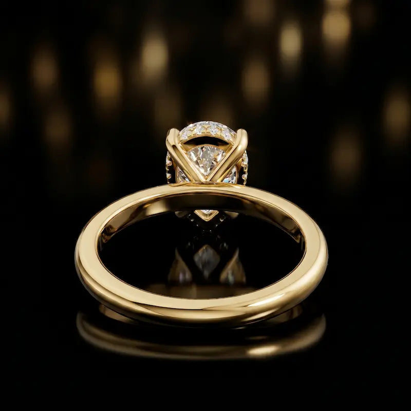 Back view of 4-claw pear cut engagement ring with hidden halo in 18kt yellow gold