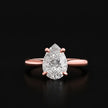 Front view of a 1.5 carat pear cut diamond solitaire engagement ring in an 18kt rose gold 4 claw setting by TJ Diamond