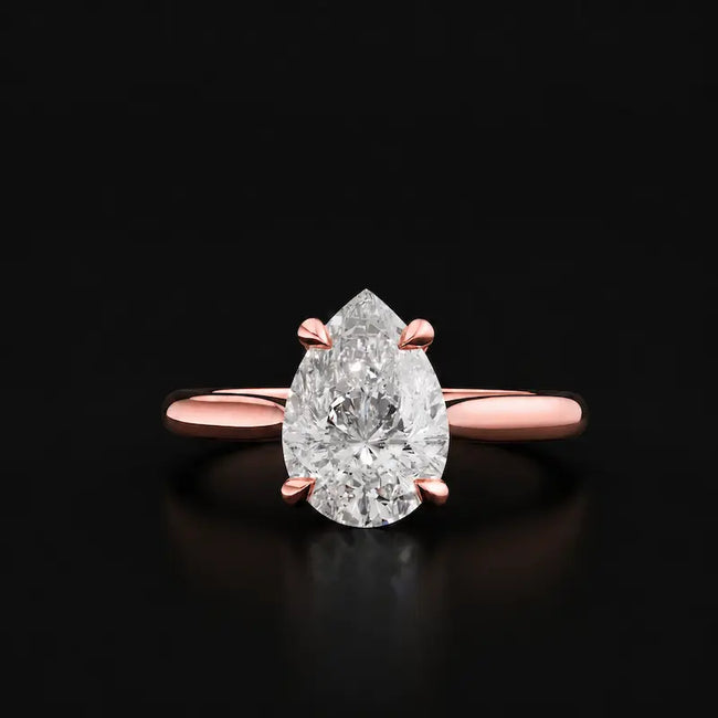 Front view of a 1.5 carat pear cut diamond solitaire engagement ring in an 18kt rose gold 4 claw setting by TJ Diamond