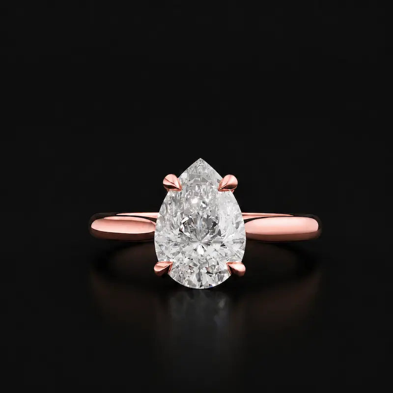 Front view of a 1.5 carat pear cut diamond solitaire engagement ring in an 18kt rose gold 4 claw setting by TJ Diamond
