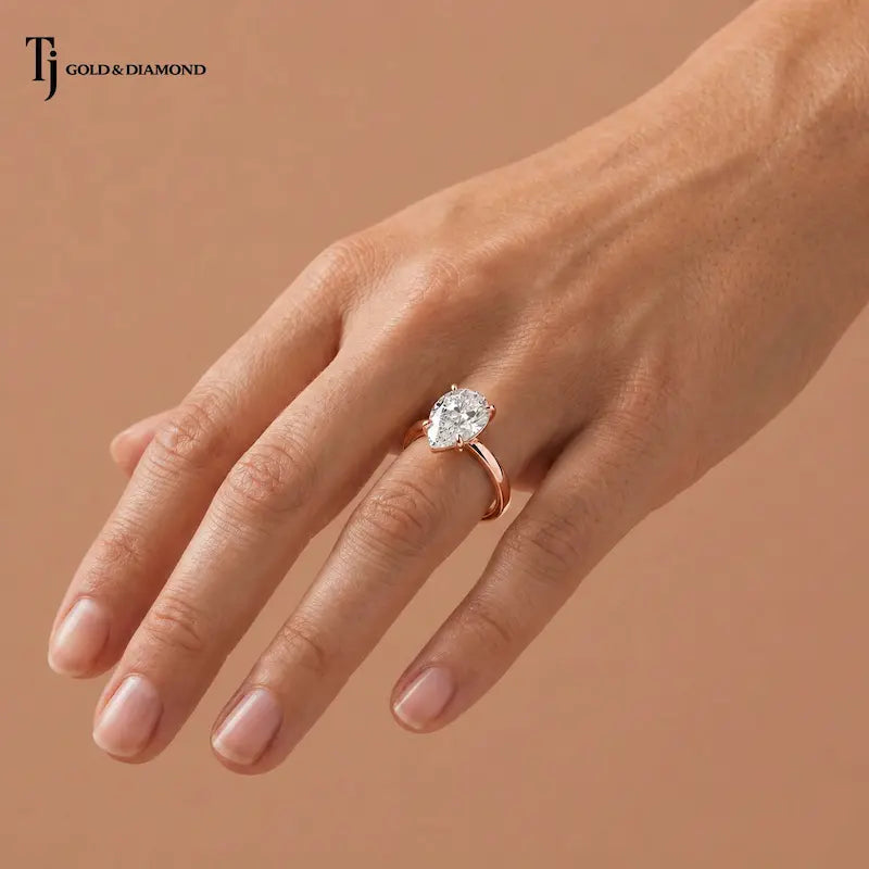 1.5 carat pear cut lab-grown diamond solitaire engagement ring in 18kt rose gold worn on hand