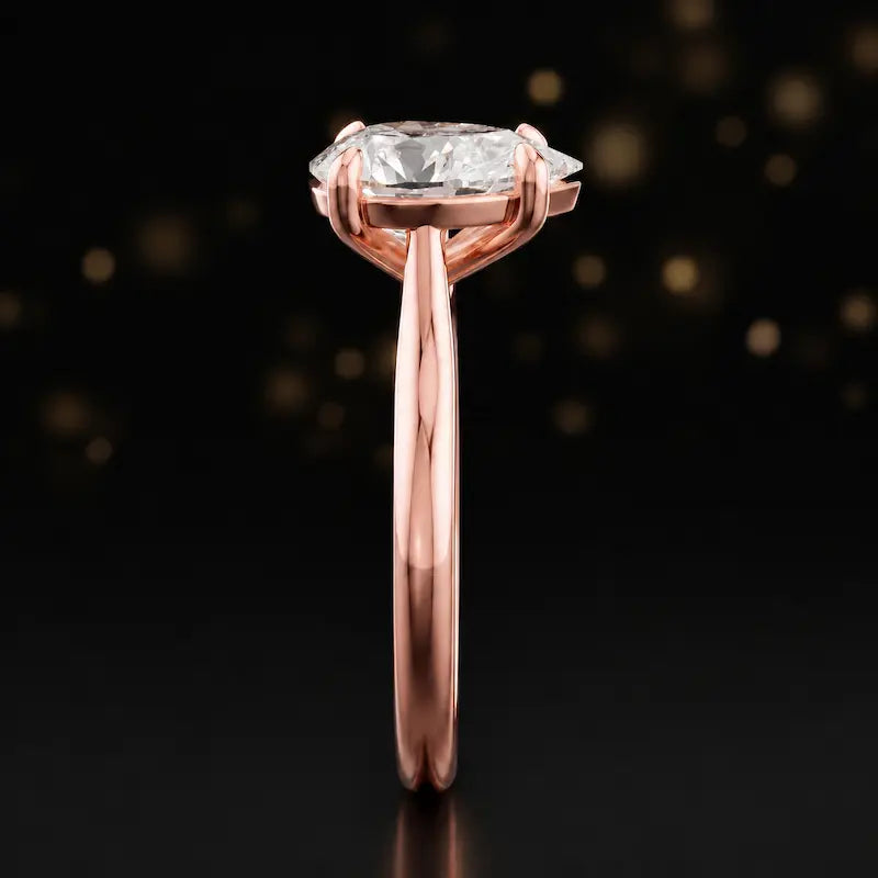 Side profile of a 1.5 carat pear cut diamond solitaire engagement ring showing the cathedral setting and 18kt rose gold band by TJ Diamond