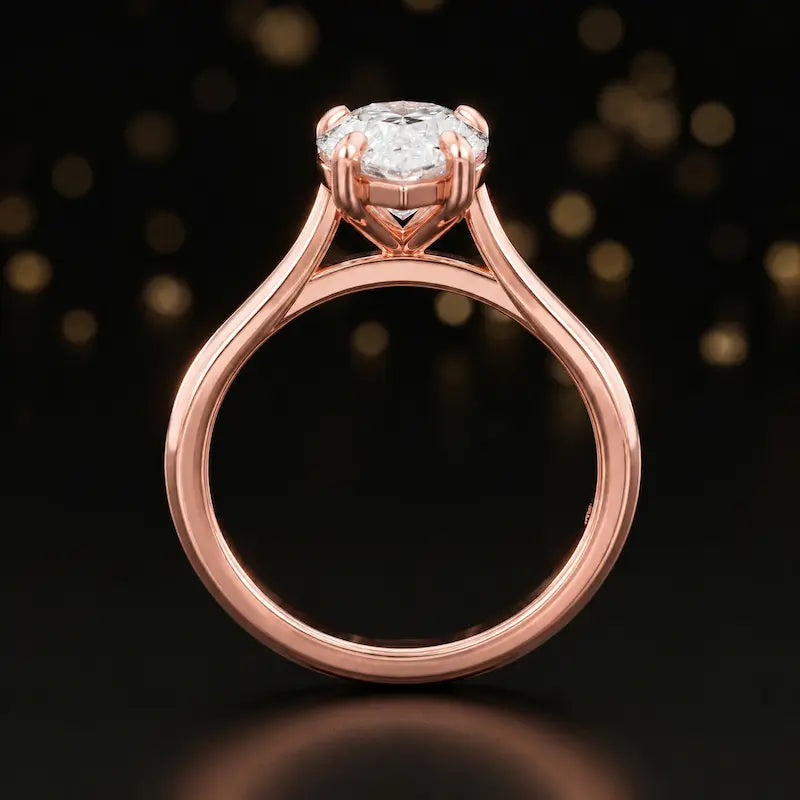 Front-on view of a 1.5 carat pear cut diamond solitaire engagement ring showing the full 18kt rose gold band and 4 claw cathedral setting by TJ Diamond