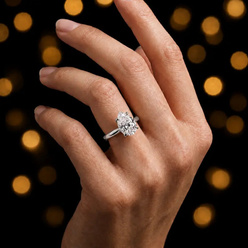 1.5 carat pear cut diamond solitaire engagement ring in an 18kt white gold 4 claw setting worn on a hand, by TJ Diamond