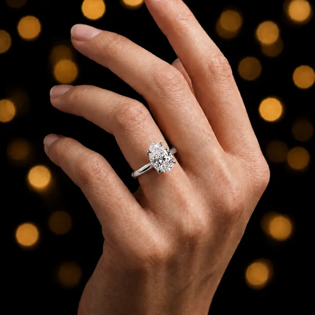 1.5 carat pear cut diamond solitaire engagement ring in an 18kt white gold 4 claw setting worn on a hand, by TJ Diamond