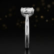 Side profile of a 1.5 carat pear cut diamond solitaire engagement ring showing the cathedral setting and 18kt white gold band by TJ Diamond