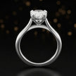 Front-on view of a 1.5 carat pear cut diamond solitaire engagement ring showing the full 18kt white gold band and 4 claw cathedral setting by TJ Diamond