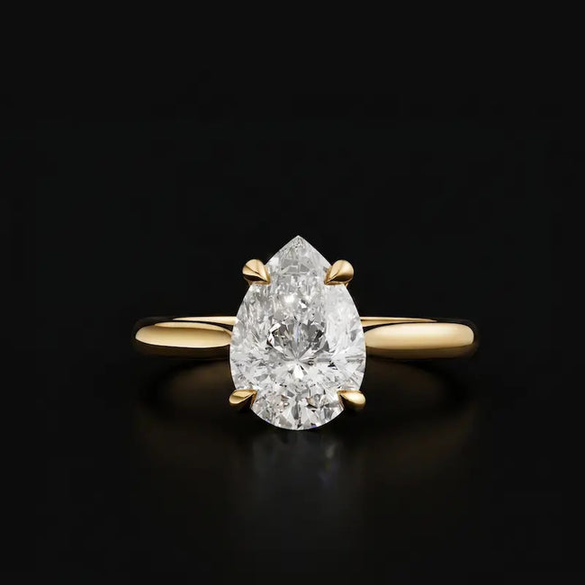 Front view of a 1.5 carat pear cut diamond solitaire engagement ring in an 18kt yellow gold 4 claw setting by TJ Diamond
