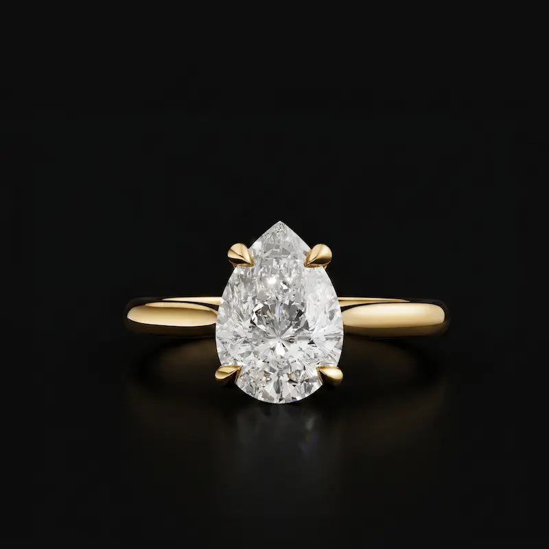 Front view of a 1.5 carat pear cut diamond solitaire engagement ring in an 18kt yellow gold 4 claw setting by TJ Diamond