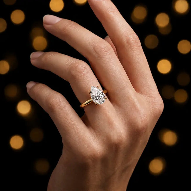 1.5 carat pear cut diamond solitaire engagement ring in an 18kt yellow gold 4 claw setting worn on a hand, by TJ Diamond