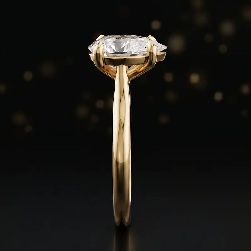 Side profile of a 1.5 carat pear cut diamond solitaire engagement ring showing the cathedral setting and 18kt yellow gold band by TJ Diamond