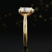 Side profile of a 1.5 carat pear cut diamond solitaire engagement ring showing the cathedral setting and 18kt yellow gold band by TJ Diamond