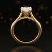 Front-on view of a 1.5 carat pear cut diamond solitaire engagement ring showing the full 18kt yellow gold band and 4 claw cathedral setting by TJ Diamond