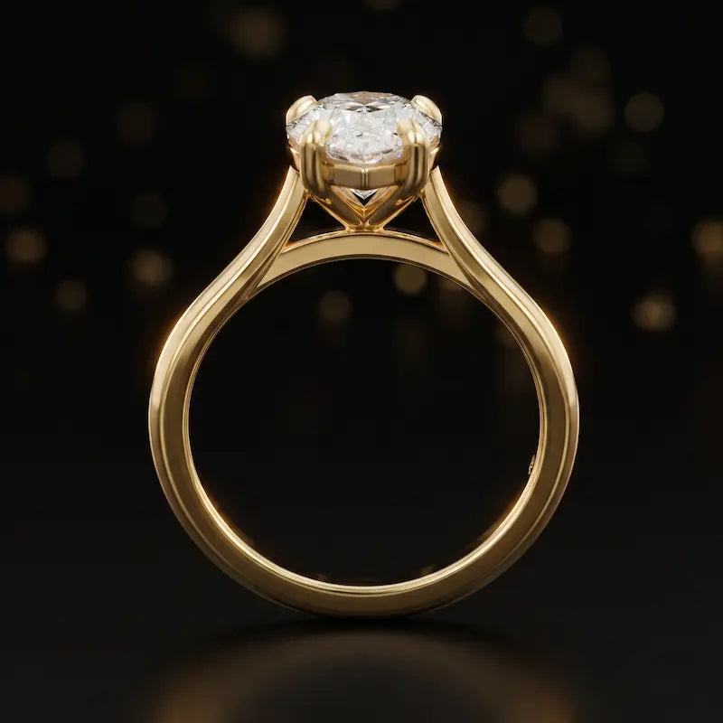 Front-on view of a 1.5 carat pear cut diamond solitaire engagement ring showing the full 18kt yellow gold band and 4 claw cathedral setting by TJ Diamond