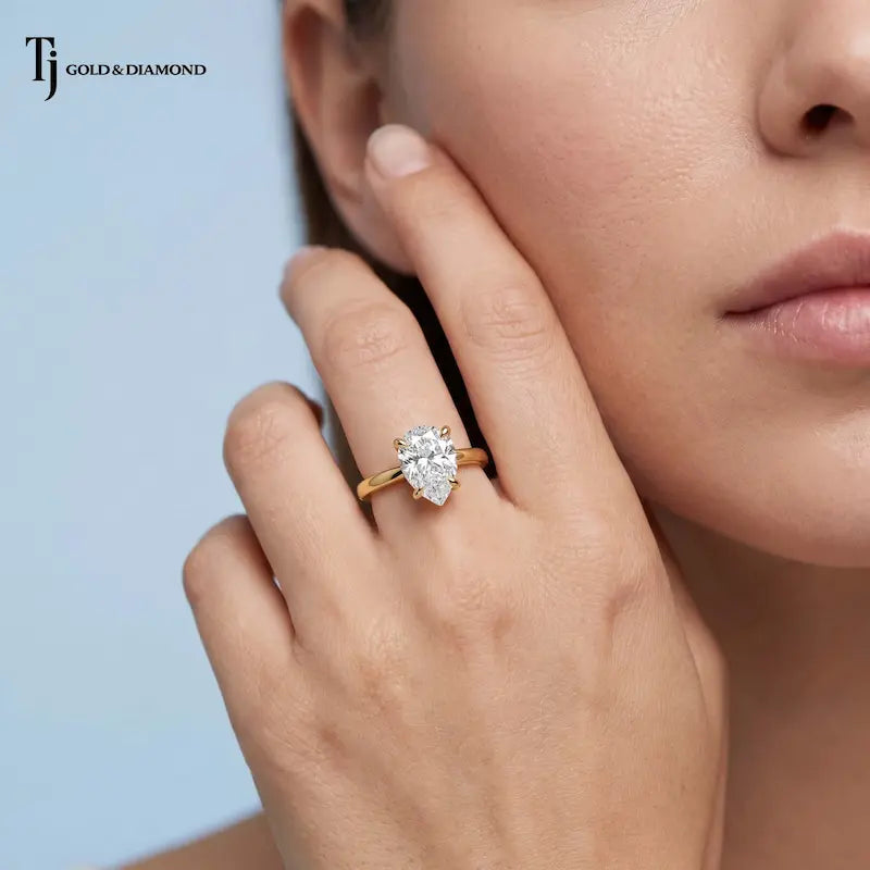 1.5 carat pear cut lab-grown diamond solitaire engagement ring in 18kt yellow gold on model