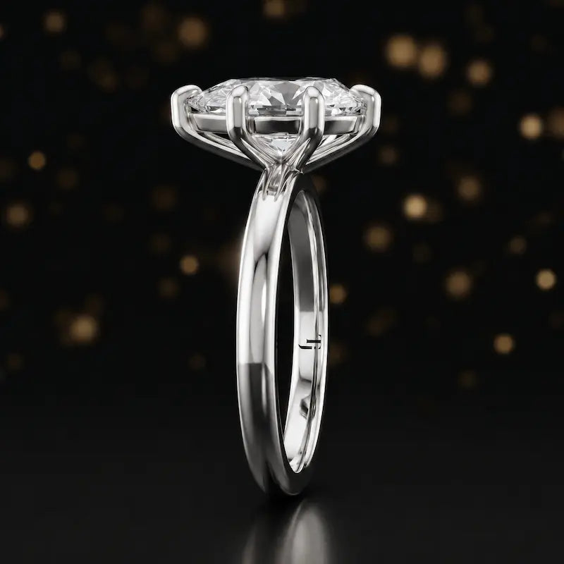 Side profile of a 1.5 carat pear cut diamond solitaire engagement ring showing the cathedral setting and 18kt white gold band by TJ Diamond