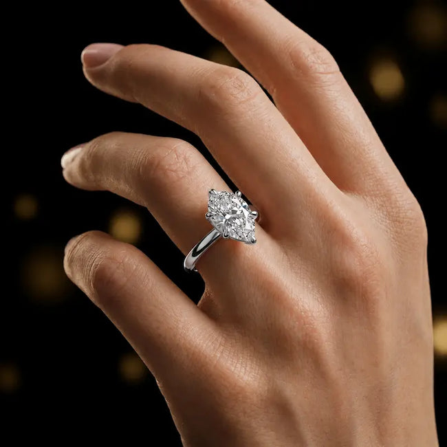 1.5 carat pear cut diamond solitaire engagement ring in an 18kt white gold 6 claw setting worn on a hand, by TJ Diamond