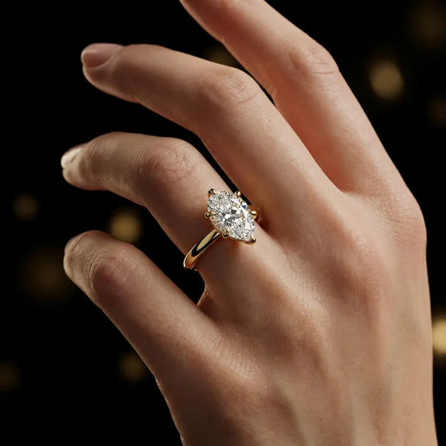 1.5 carat pear cut diamond solitaire engagement ring in an 18kt yellow gold 6 claw setting worn on a hand, by TJ Diamond