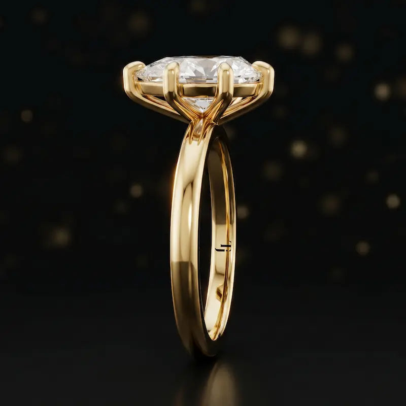 Front-on view of a 1.5 carat pear cut diamond solitaire engagement ring showing the full 18kt yellow gold band and 6 claw cathedral setting by TJ Diamond
