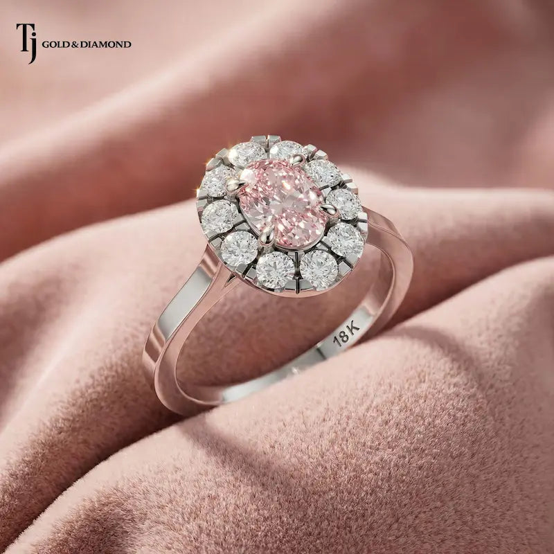 Angled close-up of an Oval Lab-Created Pink Diamond Halo Ring in polished 18kt white gold highlighting the oval pink diamond and sparkling halo.