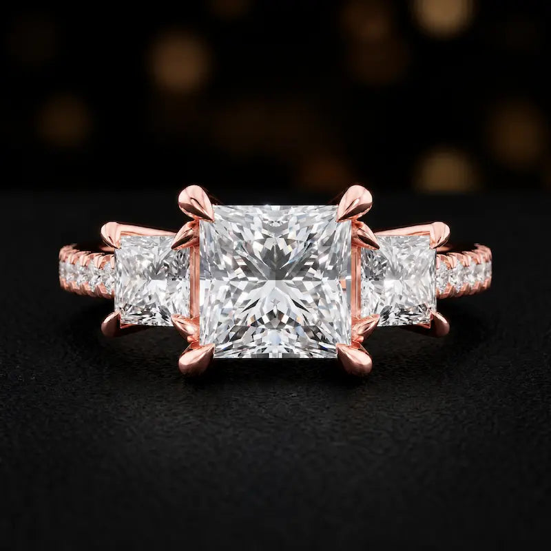 Front view of a princess cut three-stone lab-grown diamond engagement ring in 18kt rose gold with diamond shoulders
