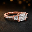Side view of a princess cut three-stone lab-grown diamond engagement ring in 18kt rose gold with diamond shoulders