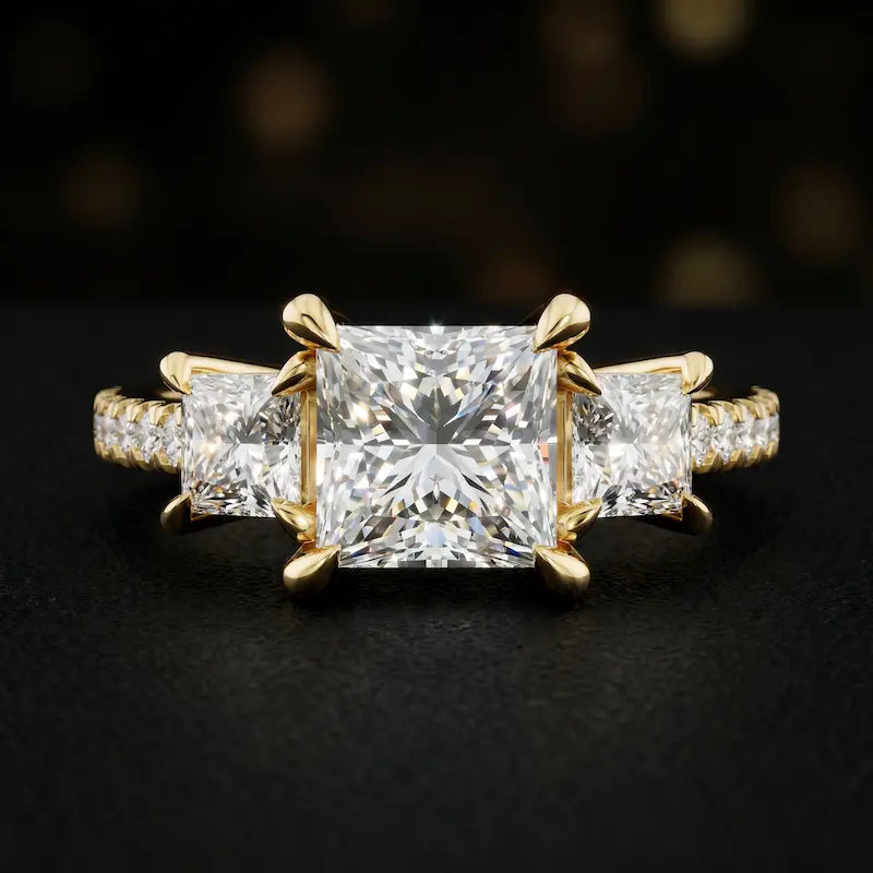 Front view of a princess cut three-stone lab-grown diamond engagement ring in 18kt yellow gold with diamond shoulders