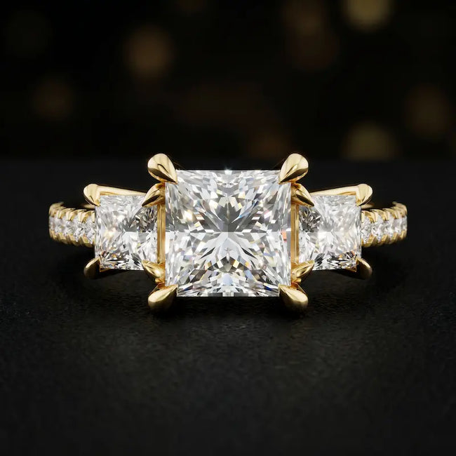 Front view of a princess cut three-stone lab-grown diamond engagement ring in 18kt yellow gold with diamond shoulders