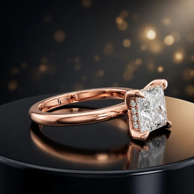 Angled view of 4-claw princess cut engagement ring with hidden halo in 18kt rose gold
