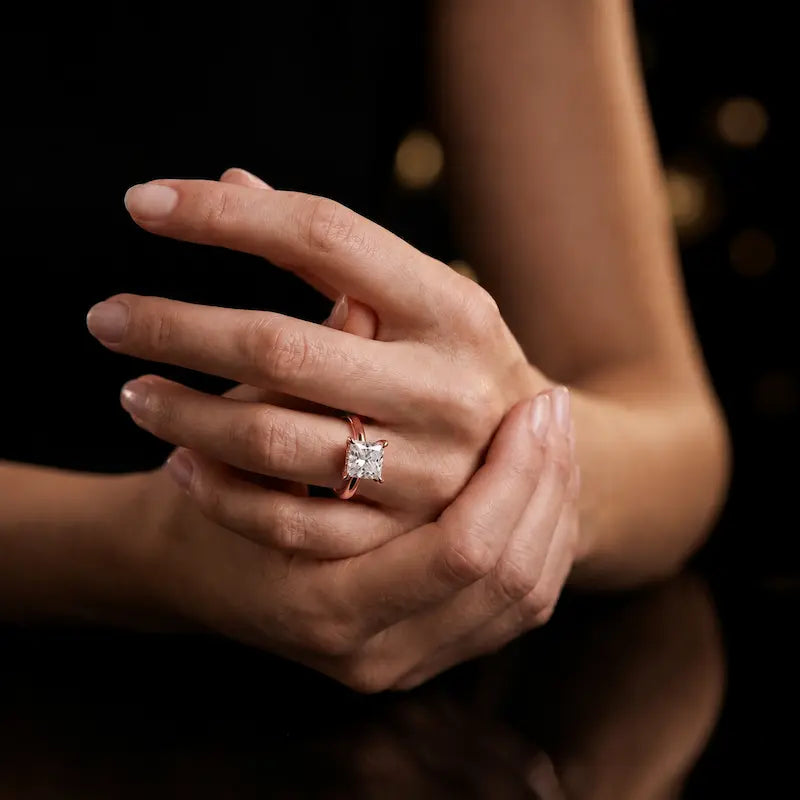 4-claw princess cut engagement ring with hidden halo in 18kt rose gold, worn on hand