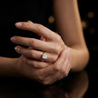 4-claw princess cut engagement ring with hidden halo in 18kt yellow gold, worn on hand