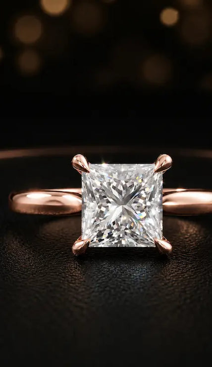 Front view of a 1.5 carat princess cut diamond solitaire engagement ring in an 18kt rose gold 4 claw setting by TJ Diamond