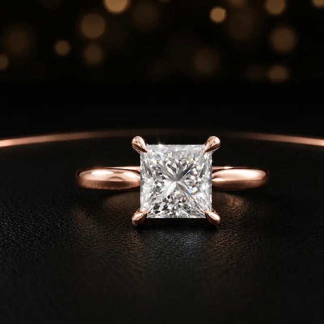 Front view of a 1.5 carat princess cut diamond solitaire engagement ring in an 18kt rose gold 4 claw setting by TJ Diamond