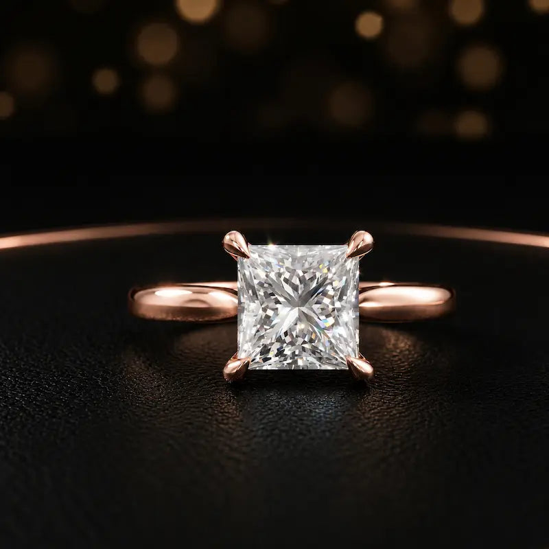 Front view of a 1.5 carat princess cut diamond solitaire engagement ring in an 18kt rose gold 4 claw setting by TJ Diamond