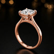 Angled side view of a 1.5 carat princess cut diamond solitaire engagement ring in an 18kt rose gold 4 claw setting by TJ Diamond
