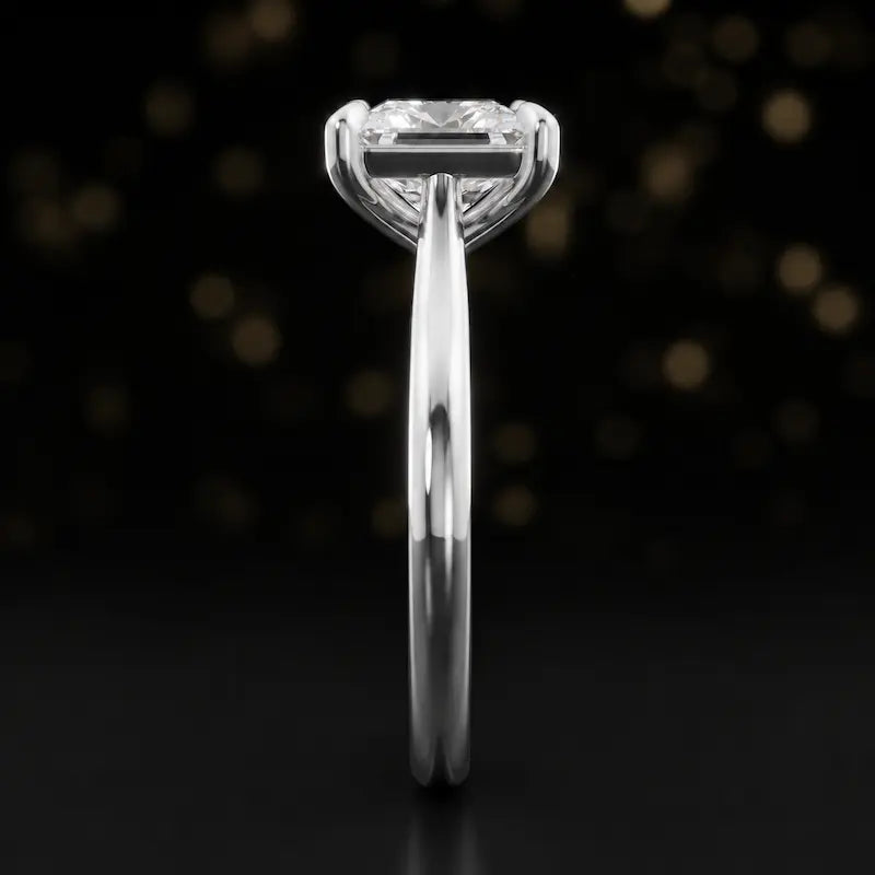 Side profile of a 1.5 carat princess cut diamond solitaire engagement ring showing the cathedral setting and 18kt white gold band by TJ Diamond