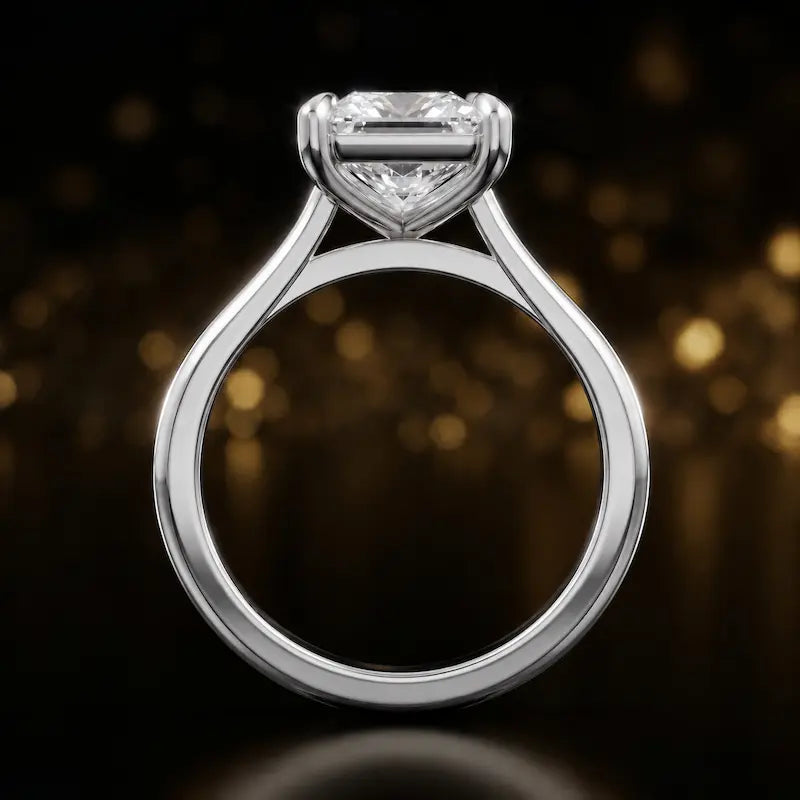 Front-on view of a 1.5 carat princess cut diamond solitaire engagement ring showing the full 18kt white gold band and 4 claw cathedral setting by TJ Diamond.