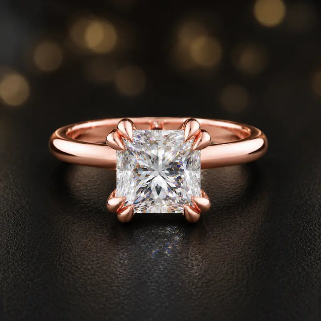 Front view of a 1.5 carat princess cut diamond solitaire engagement ring in an 18kt rose gold 4 double claw setting by TJ Diamond