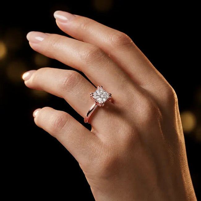 1.5 carat princess cut diamond solitaire engagement ring in an 18kt rose gold 4 double claw setting worn on a hand, by TJ Diamond