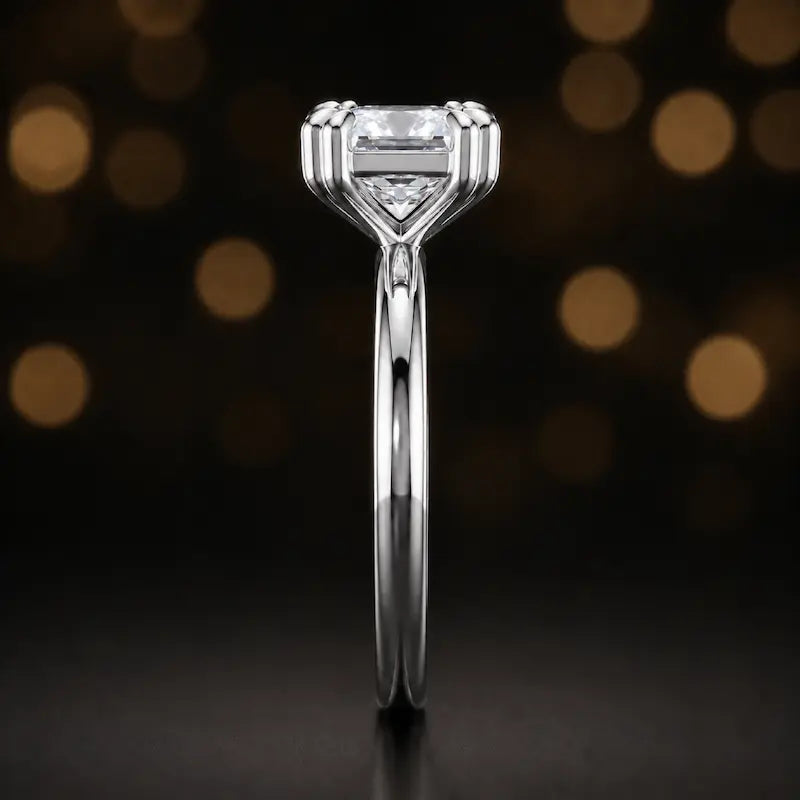 Side profile of a 1.5 carat princess cut diamond solitaire engagement ring showing the 4 double claw setting and 18kt white gold band by TJ Diamond