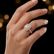 Emerald cut halo lab-grown diamond engagement ring worn on hand in 18kt rose gold.