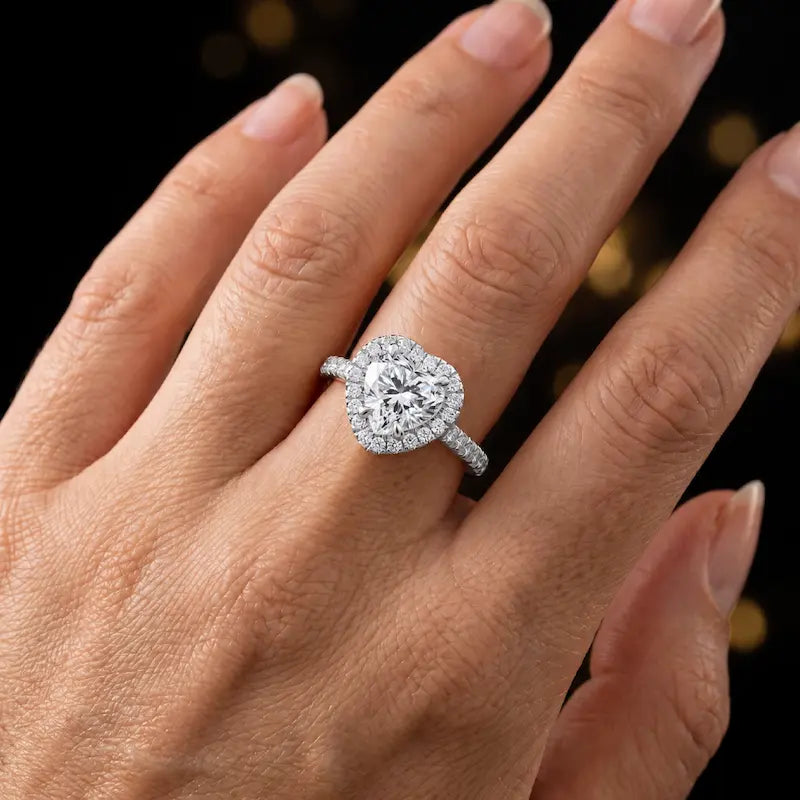 Heart cut halo lab-grown diamond engagement ring worn on hand in 18kt white gold.