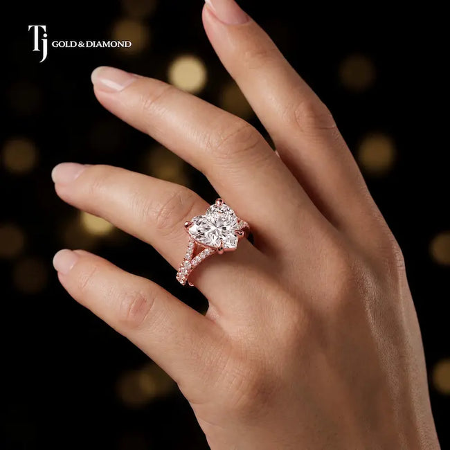 Heart cut split shank lab-grown diamond engagement ring worn on hand in 18kt rose gold.