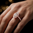 Marquise cut halo lab-grown diamond engagement ring worn on hand in 18kt rose gold.