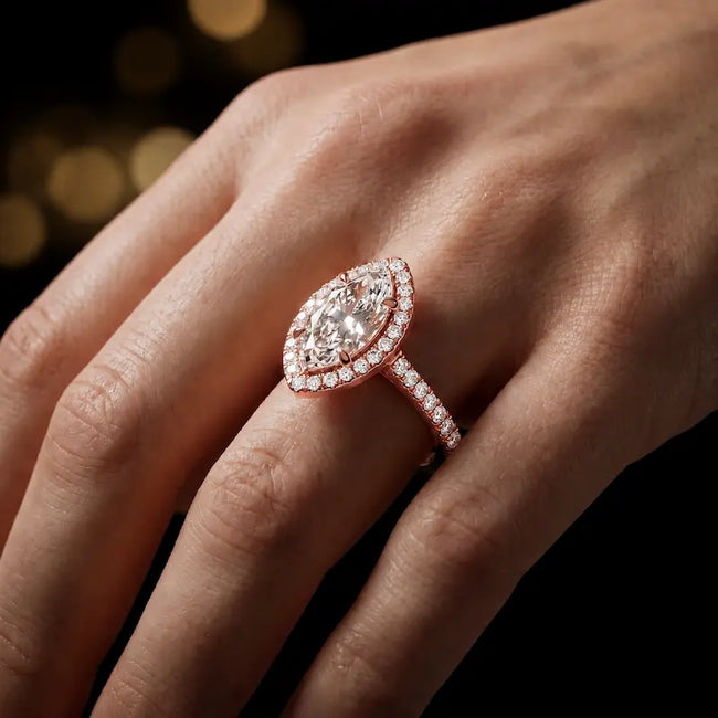 Marquise cut halo lab-grown diamond engagement ring worn on hand in 18kt rose gold.