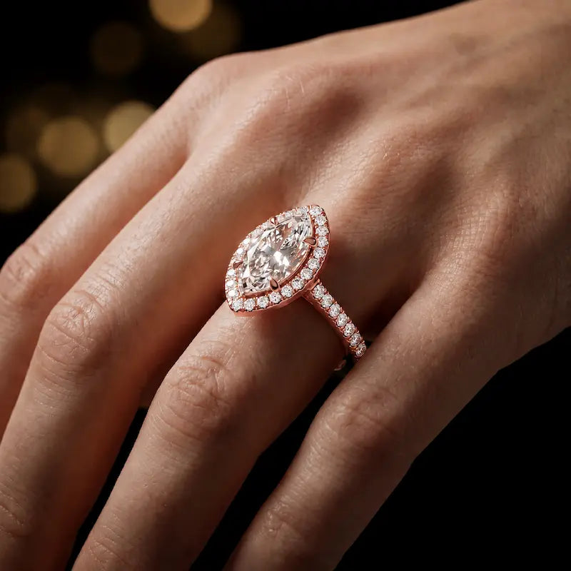 Marquise cut halo lab-grown diamond engagement ring worn on hand in 18kt rose gold.