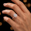 Oval cut halo lab-grown diamond engagement ring worn on hand in 18kt rose gold.