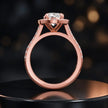 Side view of an oval cut halo lab-grown diamond engagement ring with diamond-set shoulders in 18kt rose gold.
